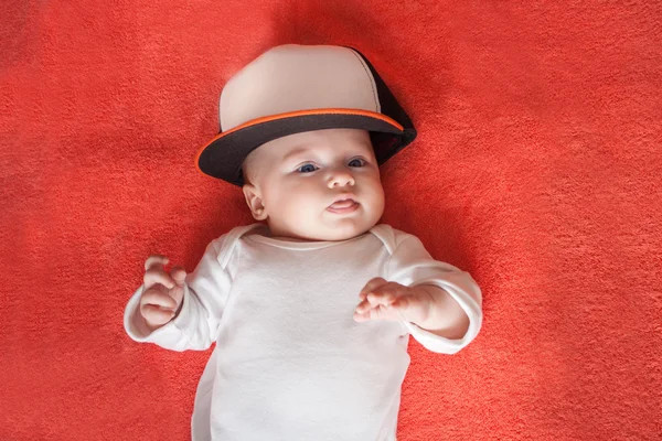 Bebé usando gorra deportiva muestra su lengua —  Fotos de Stock