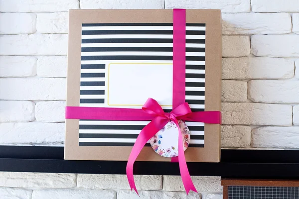 Подарочная коробка на полке с декорированными черными полосами — стоковое фото