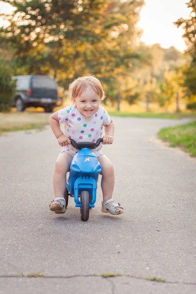 Actieve kind spelen en fietsen buitenshuis Stockfoto
