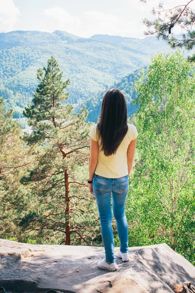Młoda dziewczyna, pobyt na skale i patrząc na góry lagunowe oraz ogród Zdjęcia Stockowe bez tantiem