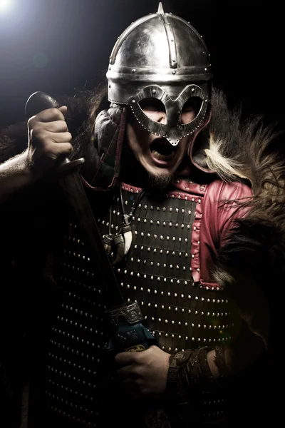 Ουρλιάζοντας viking πολεμιστής με ξίφος, πανοπλία και περικεφαλαία πάνω από blac — Φωτογραφία Αρχείου