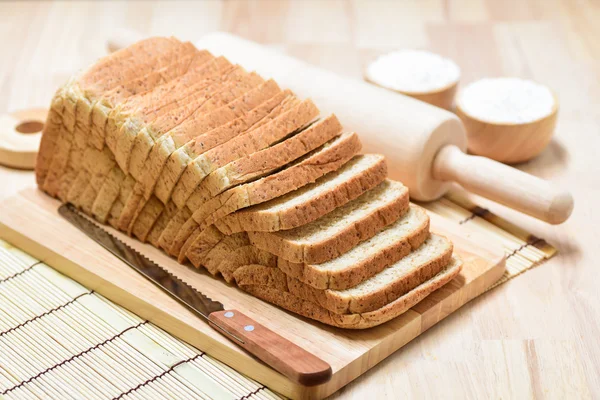 木のテーブルの上でパンをスライス — ストック写真