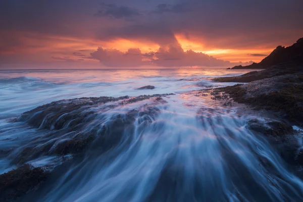 Deniz dalgaları plajda kayaya çarpıyor. — Stok fotoğraf