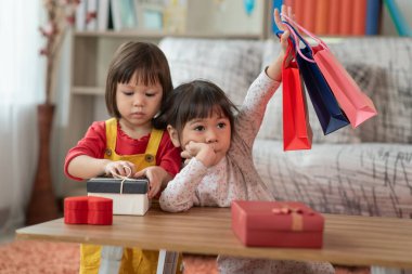 Kolları havada mutlu Asyalı çocuk alışveriş torbaları, hediye kutusu Noel ve yeni yıl çocuğu konsepti