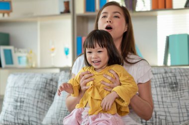 Anne evde kızıyla eğleniyor ve oynuyor, mutlu Asyalı çocuk, aile kavramı