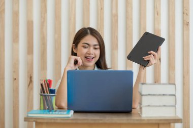 Genç Asyalı iş kadınının portresi evinde dizüstü bilgisayarla çalışıyor, evde çalışıyor, iş konseptinde çalışıyor.