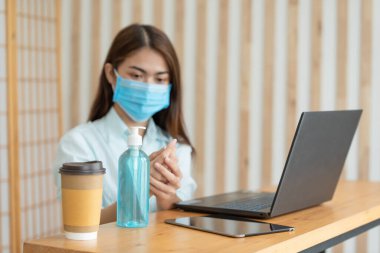 Korumalı maske takan ve alkol antiseptik jel kullanan Asyalı kadın temiz el yıkama antivirüs bakterisi kirli cilt bakterisi Coronavirüs