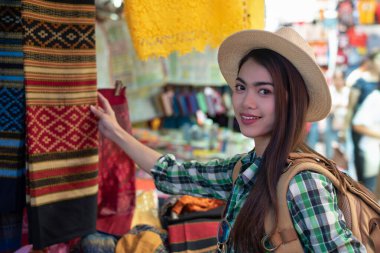 Genç Asyalı bayan turist Bangkok Tayland 'daki yerel sokak pazarında geziyor ve alışveriş yapıyor.