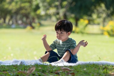 Mutlu Asyalı çocuk parkta oynarken eğleniyor.