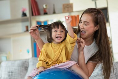 Anne evde kızıyla eğleniyor ve oynuyor, mutlu Asyalı çocuk, aile kavramı