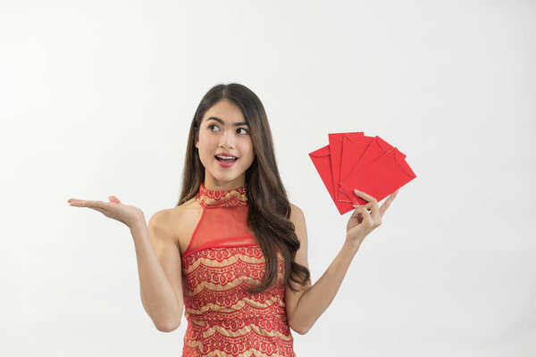 Young happy Asian woman holding red envelopes in Chinese New Year on white background