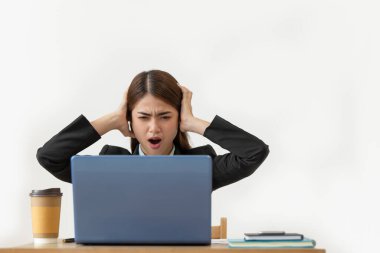 Ofisinde dizüstü bilgisayarla çalışan Asyalı genç bir iş kadını şok olmuş, yüzünde olumsuz duygular, iş stresi...