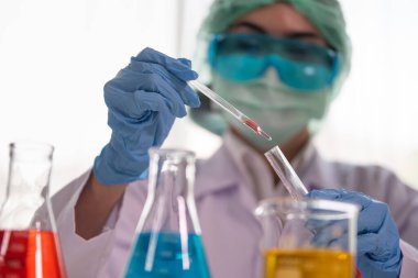 Test tüpü ile Asyalı kadın bilim adamının klinik laboratuvar, bilim ve kimya konsepti, tıp teknolojisi araştırması yapan