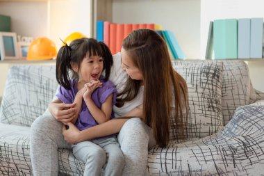 Anne evde kızıyla eğleniyor ve oynuyor, mutlu Asyalı çocuk, aile kavramı