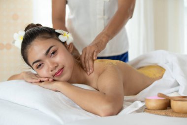 Genç Asyalı kadın spa salonunda masaj yaptırıyor, keyif alıyor ve rahatlatıyor, sağlıklı bir konsept.