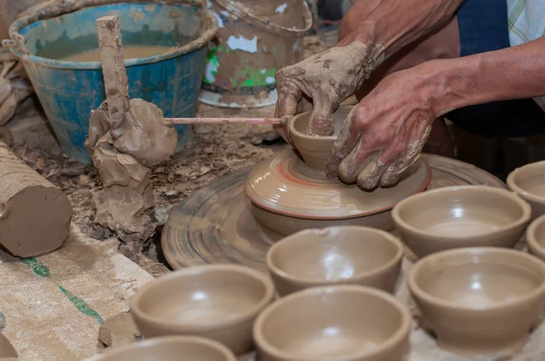 Un hombre da forma a la cerámica mientras gira en una rueda — Foto de Stock