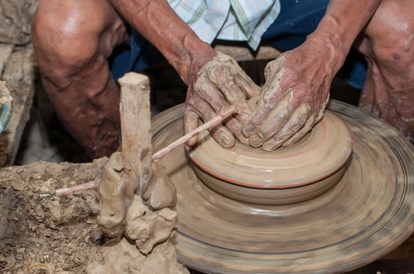 Un hombre da forma a la cerámica mientras gira en una rueda — Foto de Stock