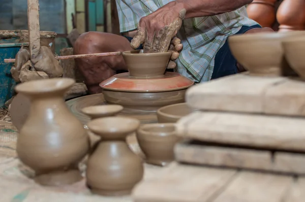 Un uomo plasma la ceramica mentre gira su una ruota — Foto Stock