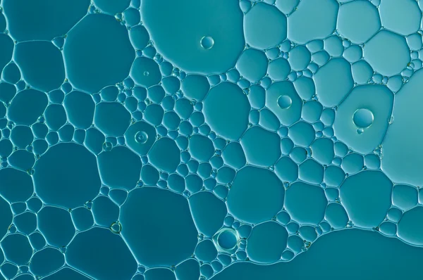 Blue drops of oil and air bubbles on the water — Stock Photo, Image