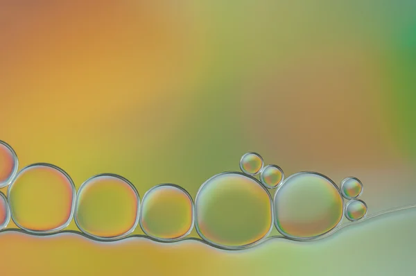 Kleurrijke druppels olie en lucht bubbels op het water — Stockfoto