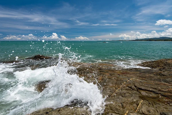 Ondas do mar linha de chicote impacto rocha na praia sob o céu azul — Fotografia de Stock