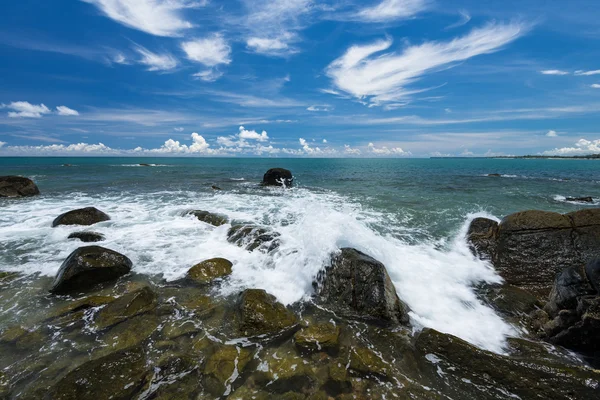 Havet vågor lash linje inverkan rock på stranden under blå himmel — Stockfoto