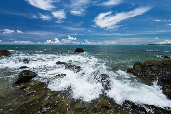 sea waves lash line impact rock on the beach under blue sky