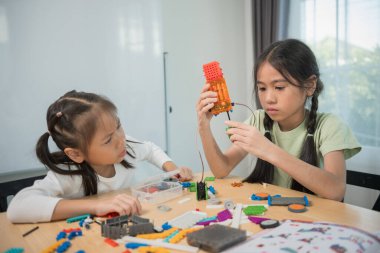 Çocuklar inşaat bloklarıyla oynuyor, çocuklar renkli plastik tuğlalarla oynuyor ve inşa ediyorlar. Erken öğrenme ve geliştirme.