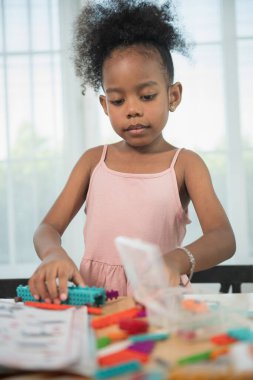 Çocuklar inşaat bloklarıyla oynuyor, çocuklar renkli plastik tuğlalarla oynuyor ve inşa ediyorlar. Erken öğrenme ve geliştirme.