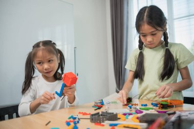 Çocuklar inşaat bloklarıyla oynuyor, çocuklar renkli plastik tuğlalarla oynuyor ve inşa ediyorlar. Erken öğrenme ve geliştirme.