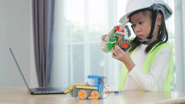 Genç bayan mühendis STEM eğitim sınıfında robotik projesinde çalışıyor. Çocuk, küçük bir robot ya da elektronik projeyi birleştirmeye ve öğrenmeye odaklanmıştır. mühendislik, yenilik, teknoloji.