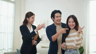 Asyalı finans danışmanı ofisteki genç çifte yeni proje yatırımını açıklıyor. Emlakçı aileyle ipotek seçeneklerini tartışıyor. Finans danışmanıyla ipotek kredisi danışmanlığı.