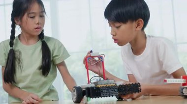 BTMM eğitim sınıfında robotik projesinde çalışan Asyalı çocuk mühendisleri. Çocuk, küçük bir robot ya da elektronik projeyi birleştirmeye ve öğrenmeye odaklanmıştır. mühendislik, yenilik, teknoloji