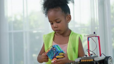 Genç Afrikalı kız mühendis STEM eğitim sınıfında robotik projesinde çalışıyor. Çocuk, küçük bir robot ya da elektronik projeyi birleştirmeye ve öğrenmeye odaklanmıştır. yenilik, teknoloji.