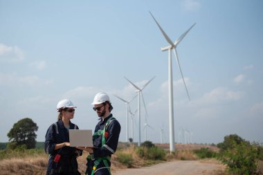 Rüzgâr türbini bakım ve onarım teknisyeni, mühendis türbinleri kontrol ediyor. Rüzgar türbini çiftliğinde bakım ve temiz güç jeneratörü sistemi çalışıyor.