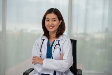 Kameraya bakan mutlu Asyalı genç kadın doktorun portresi.