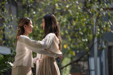 İki genç kadın, küçük bir buket beyaz çiçek tutarken arkadaşına nazikçe duygusal destek veriyor. Sahne arkadaşlığı ifade eder. rahatlık. Empati. ve hakiki insan bağlantısı..