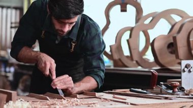 Luthier gitar yapıyor ve el aletleriyle çalışma odasında geleneksel aletler kullanıyor..
