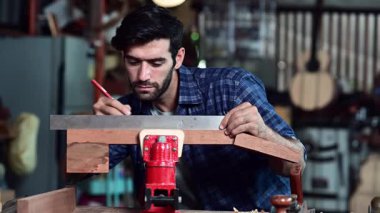 Luthier gitar yapıyor ve el aletleriyle çalışma odasında geleneksel aletler kullanıyor..