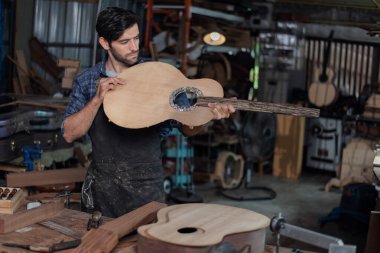 Luthier, el aletleri, sanat ve el sanatları konseptiyle çalışma odasında geleneksel aletleri kullanarak gitarın tepesini yapıyor..