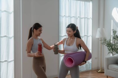 Spor giyimli sağlıklı bir Asyalı kadın evinde spor yapıyor. Spor ve dinlenme konsepti..