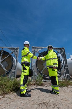 Rüzgâr türbini bakım ve onarım teknisyeni, mühendis türbinleri kontrol ediyor. Rüzgar türbini çiftliğinde bakım ve temiz güç jeneratörü sistemi çalışıyor..