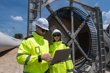 Rüzgâr türbini bakım ve onarım teknisyeni, mühendis türbinleri kontrol ediyor. Rüzgar türbini çiftliğinde bakım ve temiz güç jeneratörü sistemi çalışıyor..