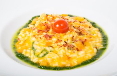 Beyaz bir tabak içinde sarı risotto