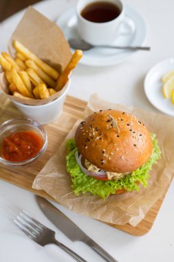 Hamburger, tahtanın üzerinde patates kızartması ile servis edilir.