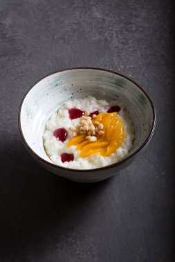 Mango ve fındıkla servis edilen pirinç lapası kasesi.