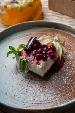 Çilek ve nane yapraklarıyla süslenmiş peynirli pasta.