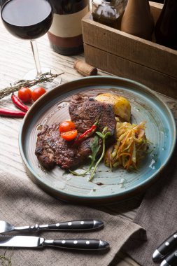 Barda kırmızı şarapla servis edilen biftek.