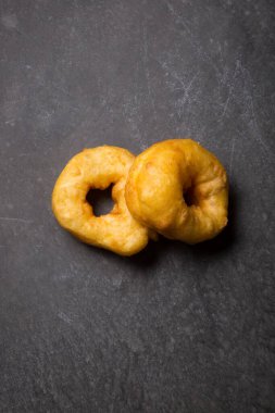 Siyah beton arka planda taze pişmiş donut.