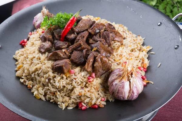 Traditional uzbek lamb pilaf food served on metal dish